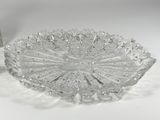 a clear glass bowl with a silver lid on a white table