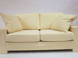 cream colored couch with pillows on it against a white background