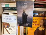 many books that are on a shelf in a room