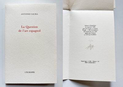 an open book sitting on top of a white table next to a piece of paper