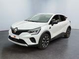 Une voiture blanche est garée dans une pièce au sol noir.