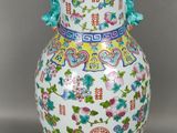 un vase blanc orné de motifs colorés sur un fond gris