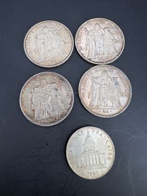 six different british coins on a black surface