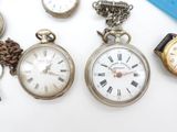 many different types of pocket watches on the table