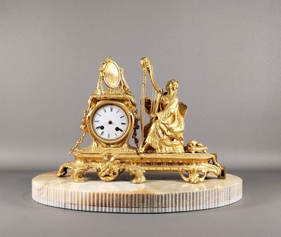 une horloge en or posée sur un socle en marbre