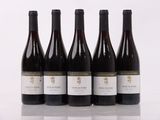 four bottles of wine are lined up on a table