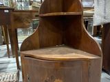 a wooden corner cabinet with a drawer on top of it