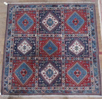 a red, blue and white rug on a wooden floor