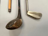 a lot of golf clubs and a golf ball on the table