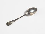 a silver spoon with a spoon handle on a white surface