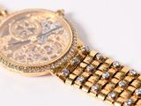 a close up of a gold watch with diamonds on it