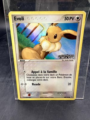La carte Pokémon se trouve dans une boîte en plastique posée sur une table.