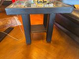 une petite table avec un plateau en verre posée sur un parquet