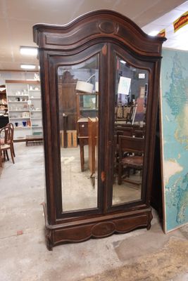 une grande armoire en bois surmontée d'un miroir