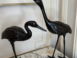 two statues of two birds on a marble table