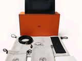 une image représentant une boîte noire et orange contenant un sac à main noir et blanc