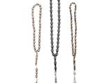 un ensemble de trois colliers en perles ornés de pompons