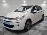 la petite voiture blanche est garée sur un sol en damier