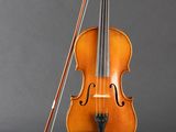 an old violin with a bow and bow rest on a stand
