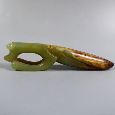 two pieces of green jade are sitting on a white surface