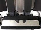 four speakers sitting on top of a table in a room