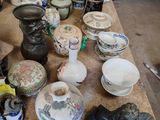 une table sur laquelle sont disposés de nombreux vases et assiettes de toutes sortes