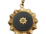 un gros plan d'un pendentif doré et noir sur fond blanc
