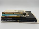 trois livres empilés sur une surface blanche