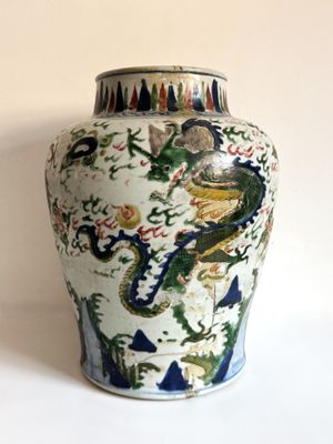 un vase orné d'un dragon posé sur une table