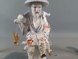 a figurine of a man holding a fish and a bird