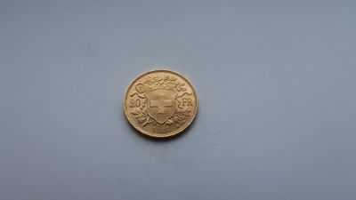 a close up of a gold coin on a white surface