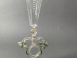 a glass with a flower on it on a table