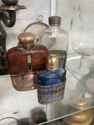 une étagère en verre sur laquelle sont posées de nombreuses bouteilles en verre