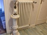 un radiateur blanc dans un coin de la pièce, près d'une porte