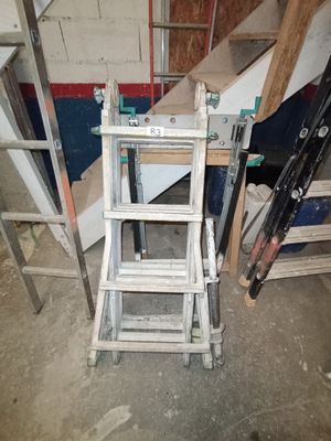 une échelle posée à côté d'un tas de bois