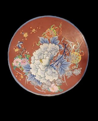 a plate with flowers and birds on it on a black background