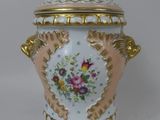 un vase blanc et doré orné d'une fleur rose et jaune