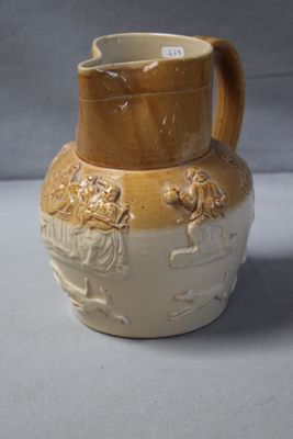 a brown and white vase with a handle on a table