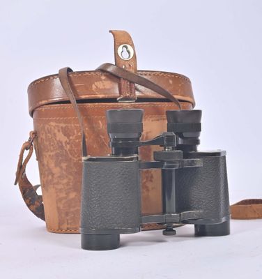 a brown bag and a pair of binoculars on a white surface