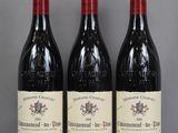 three bottles of red wine sitting on top of a glass table