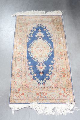 an antique persian rug with a blue border and a floral design