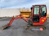 a small red excavator that is parked in a parking lot