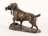 statue of a dog with a bird in its mouth on a rock