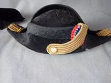 a black hat with a red, white, and blue ribbon on it