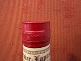 une bouteille d'alcool posée sur une table à côté d'une valise