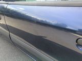 a close up of a car door handle with a reflection on the door