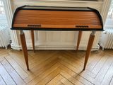 un bureau en bois avec un plateau noir posé sur un parquet en bois massif