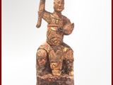 une statue représentant un homme assis sur une souche d'arbre
