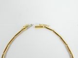 a close up of a gold necklace on a white surface