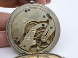a person holding a pocket watch in their hand